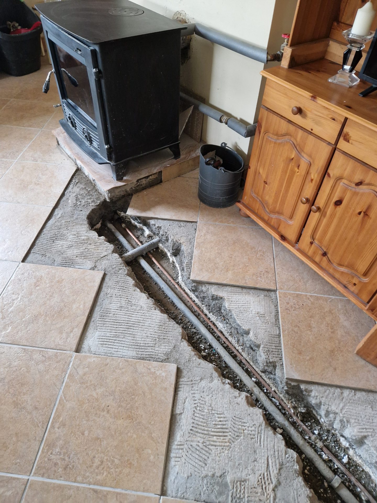 Trace and access work by a Mayo loss assessor to locate a leaking pipe under kitchen floor tiles.