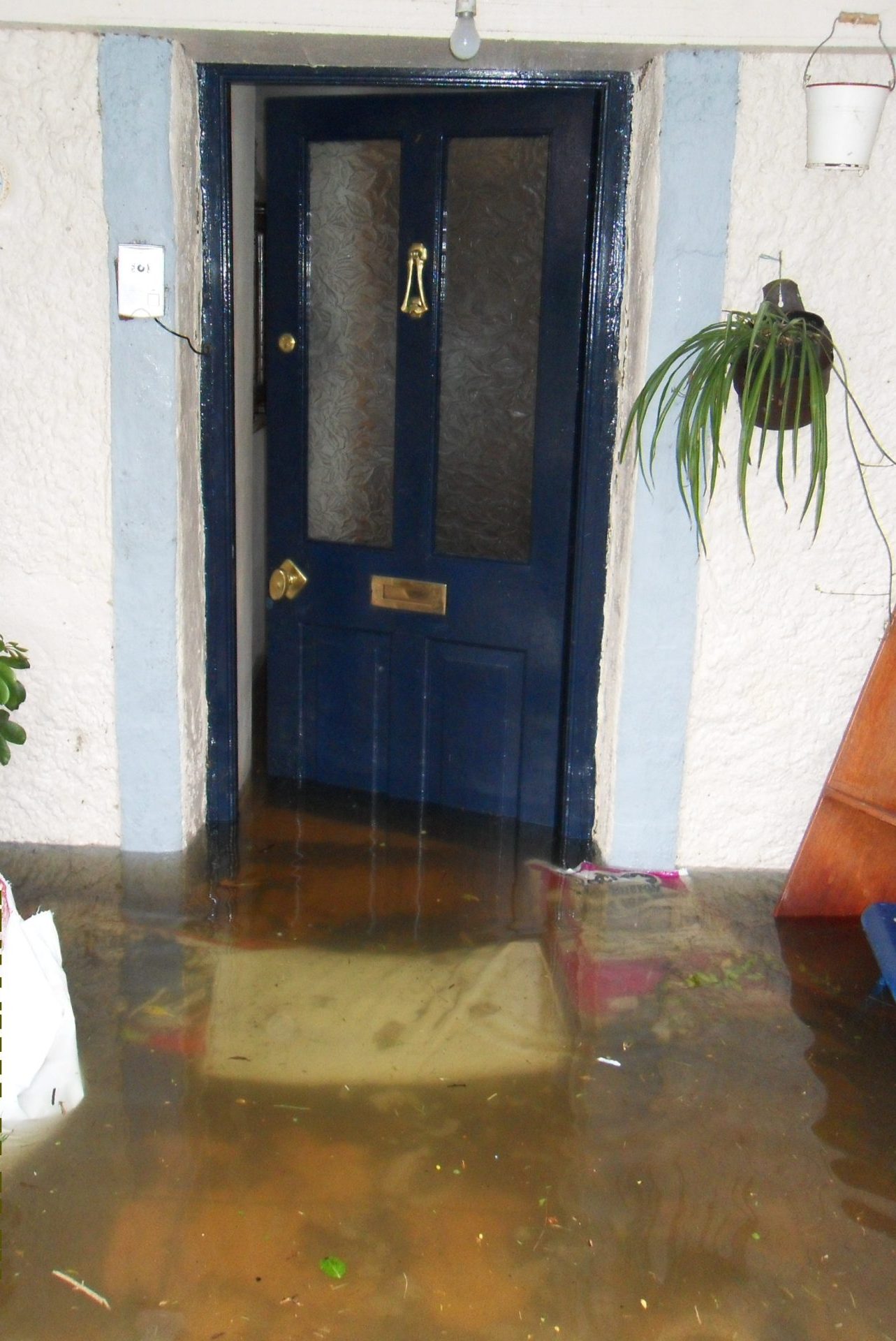 Severe river flooding at a residential front door in Tipperary, being handled by a local loss assessor.